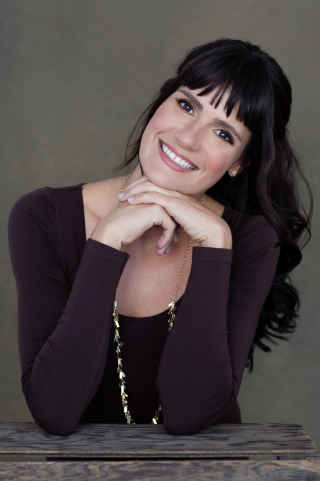 Freer (woman) smiling and facing forward over tabletop